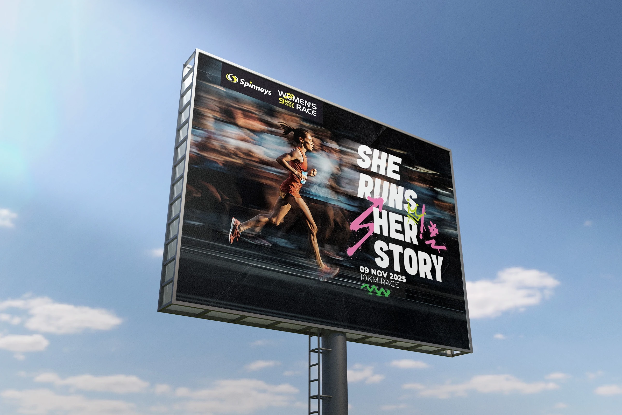 Freestanding race campaign billboard showing runners and the headline ‘She Runs Her Story’