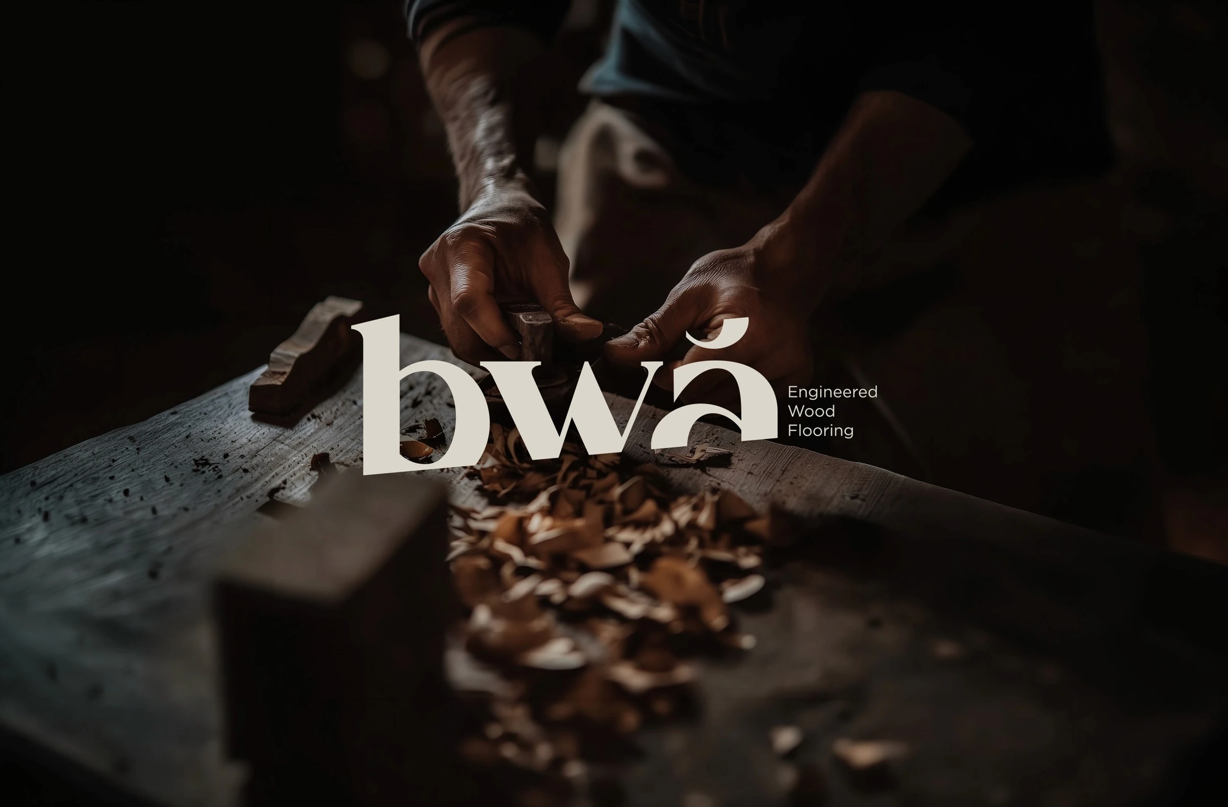 Cream BWĀ wordmark over a photograph of hands carving wood