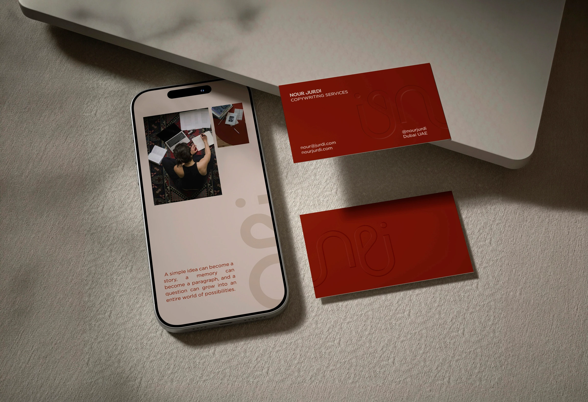 Nour Jurdi mobile website mockup beside coral-colored stationery